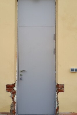 Узкая и высокая железная дверь с верхней фрамугой