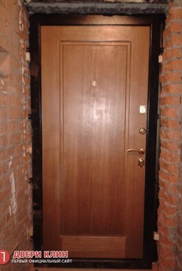 Входная дверь цвета миланский орех в старом кирпичном доме